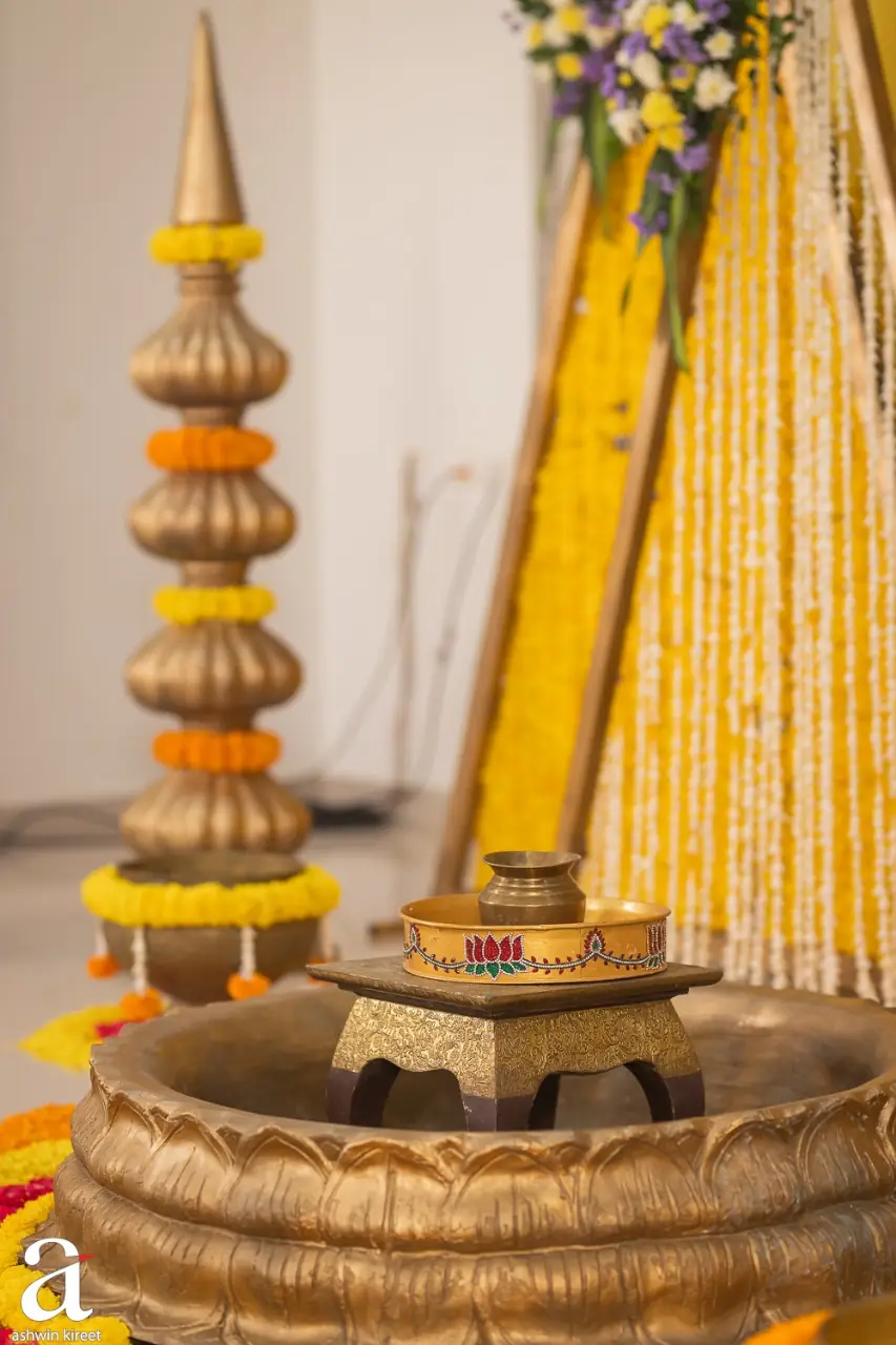 Brass urli and marigold detail from a haldi setup