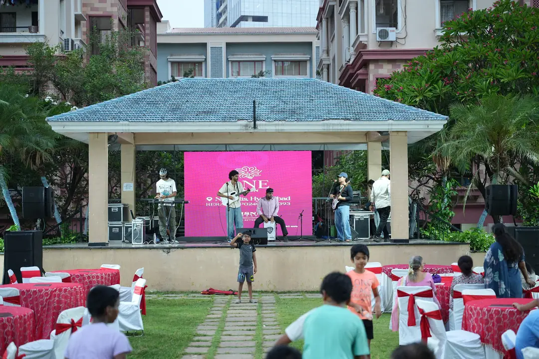 Live band on a pink-lit bandstand at the MSN Realty community event