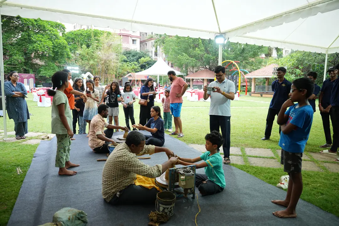Children at a pottery wheel workshop on the lawn