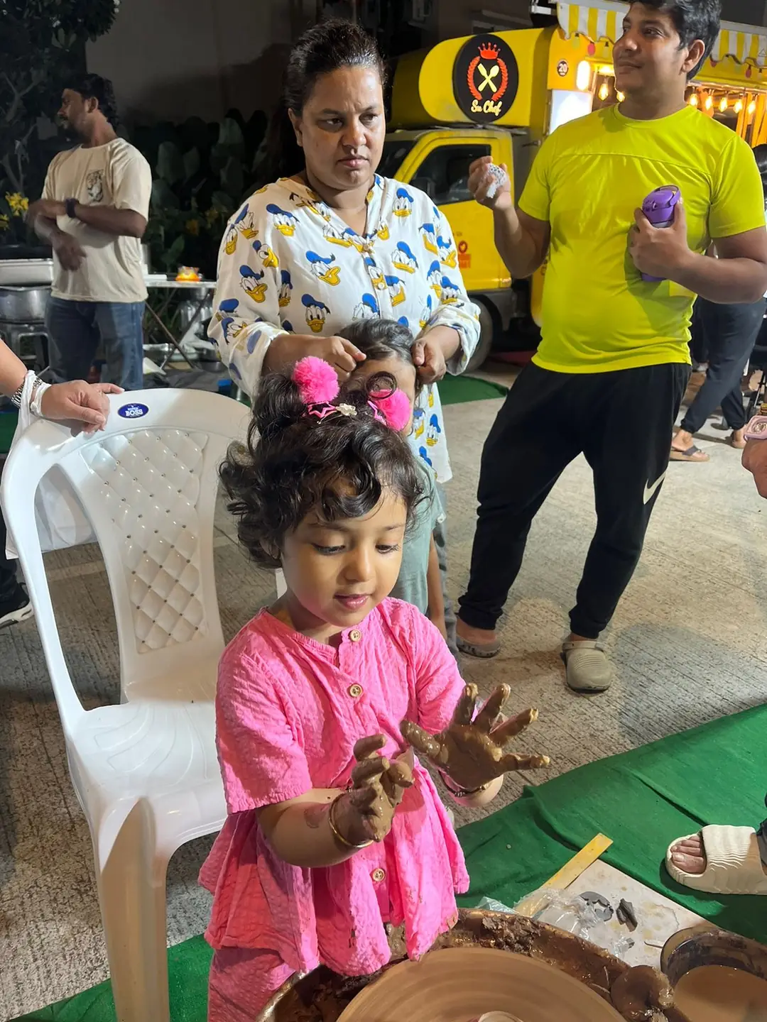 A child shaping clay at a carnival workshop