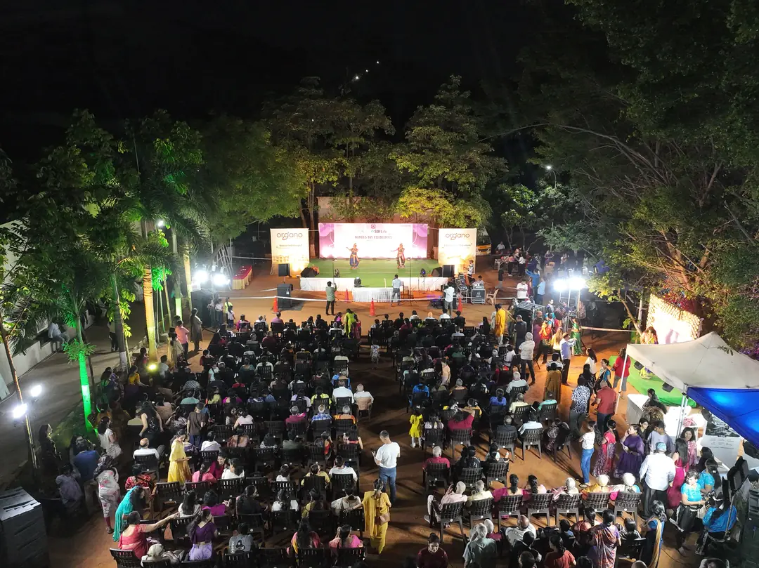 Crowd gathered in front of a lit stage at a night event